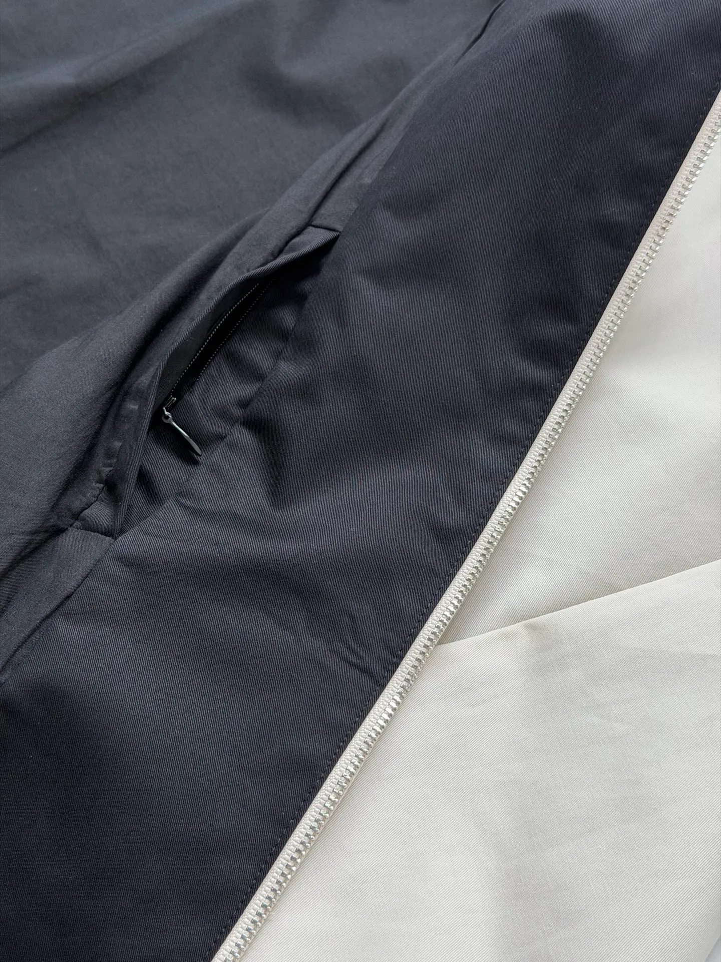 Acne Studio Retro Harrington jacket with embroidered letter logo on the back is made of custom-dyed poplin fabric with a Cream White body and Black lapels. The thickness, stiffness and matte texture of the fabric are completely in line with the original. The cutting process of the raglan sleeves, the smoothness of the zippers, the opening points of the pockets, and the routing of the pockets are all restored; the elastic elastic bands on the hem and cuffs are reproduced from the original ones, and the elasticity is in place, making it less likely to loosen and deform after long-term wear. Size：S/M/L/XL